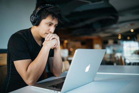 person wearing headphones looking at computer